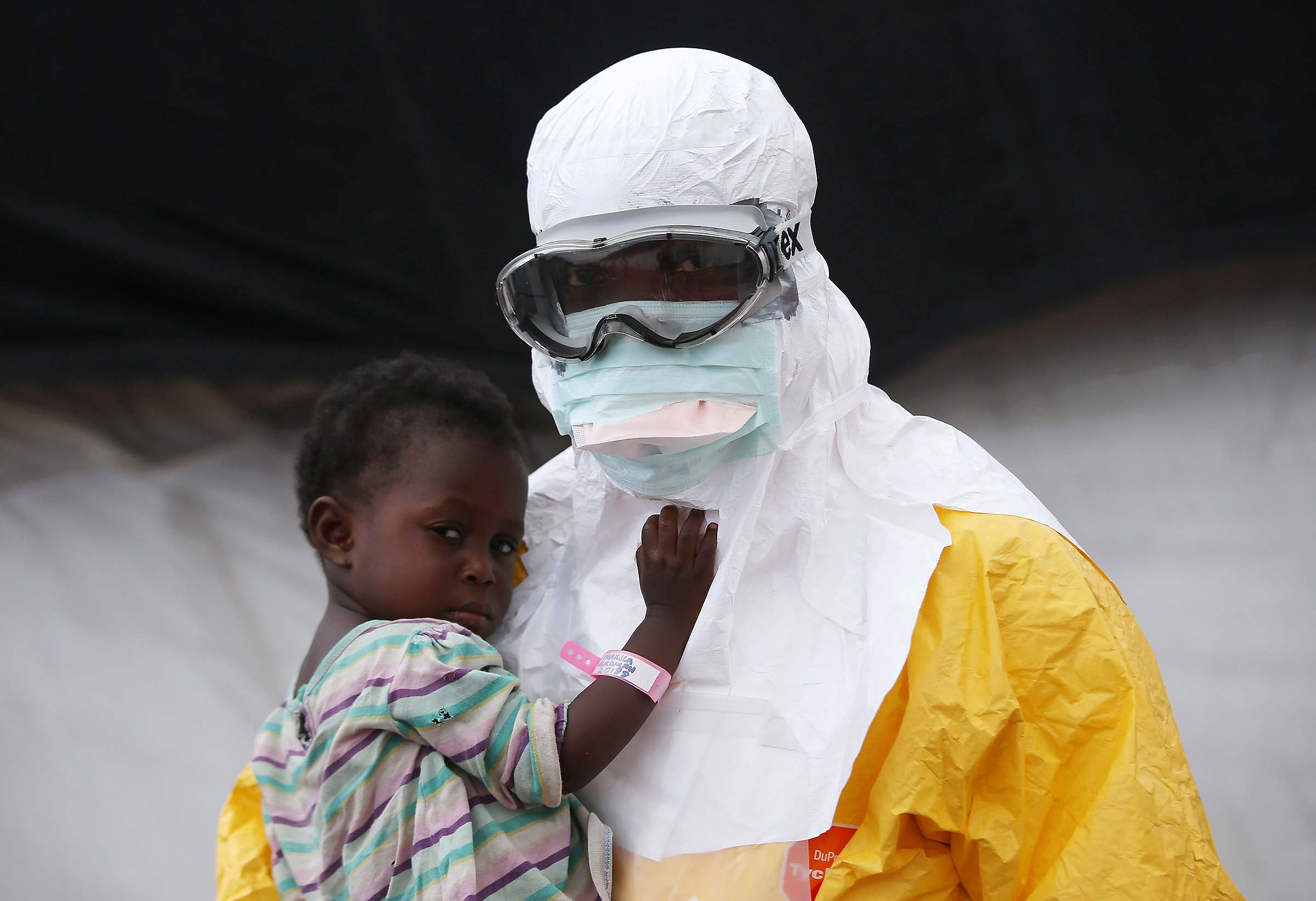 A Doctors Without Borders health worker holds a child suspected of having Ebola in the MSF treatment center in Paynesville, Liberia. Photo by John Moore