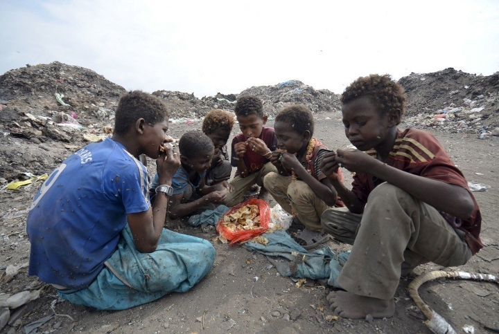 Boys eat at a rubbish dump where they are collecting recyclable waste outside Yemen's Red Sea port city of Houdieda.