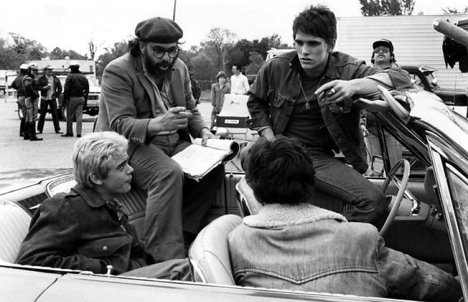 Francis Ford Coppola having a discussion with young actors Matt Dillon, C.Thomas Howell, and Ralph Machhio.