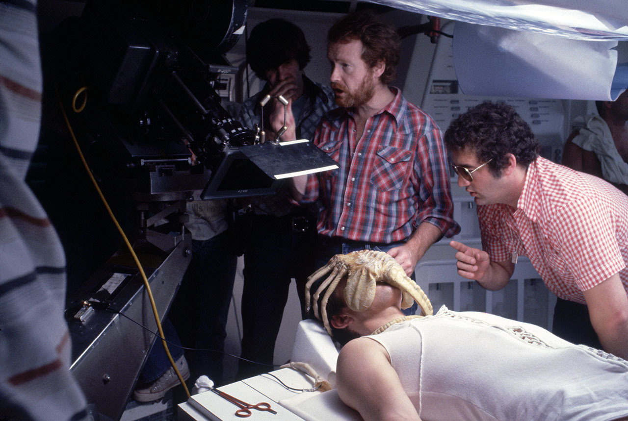 John Hurt not appearing to be bothered by the facehugger on his face while Ridley Scott gets the shot ready in Alien.