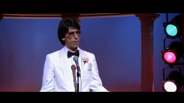 Richard Belzer was also the emcee  at the Babylon Club when the Colombians try to kill Tony Montana in Scarface.