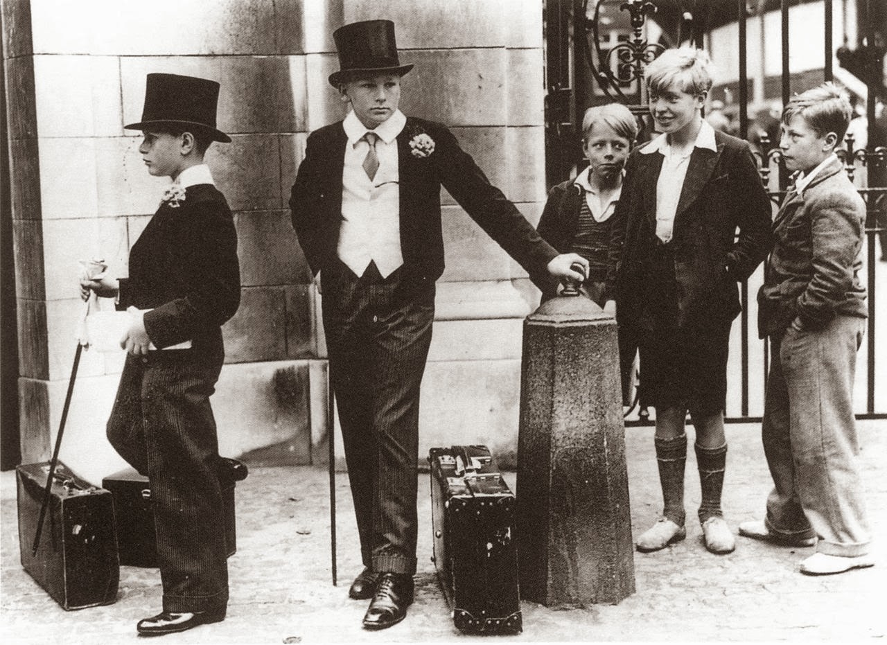 Young British aristocrats stand near to some less privileged children in 1937.