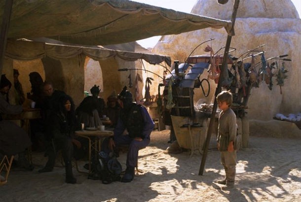 Star Wars Episode I: The Phantom Menace: If you pay attention, you can spot a Jedi by the name of Quinlan Vos eating near where Sebulba was eating before Jar Jar’s antics got him in trouble. Just before Anakin comes into the frame for the first time in the scene, you can see Quinlan’s face. You might want to play it in slow motion, though, as he’s quickly covered by Anakin. Quinlan Vos is the man with the yellow stripe going horizontally across his nose. You can even visit the movie set where this was shot if you’re really interested in reliving the magic of Star Wars.