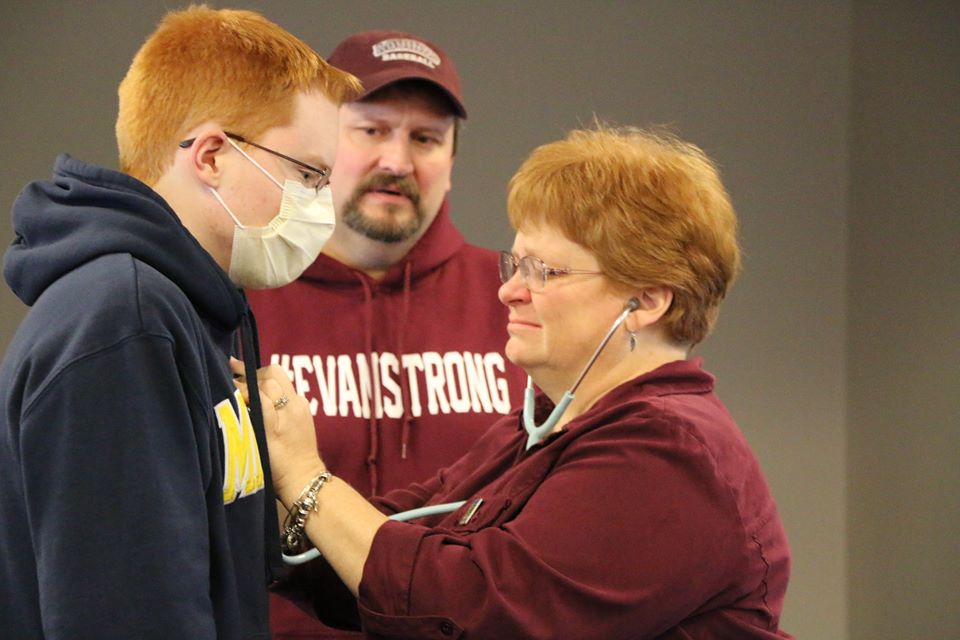 A mother listening to her sons heart beating in the chest of another person after transplant