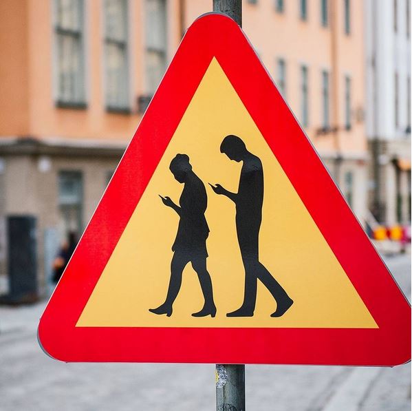 A road sign warns drivers that they may encounter pedestrians who are deeply absorbed in their smartphones, in Stockholm, Sweden