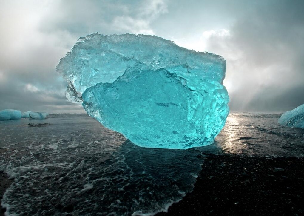 A stunning blue iceberg on the volcanic beaches of Iceland.
