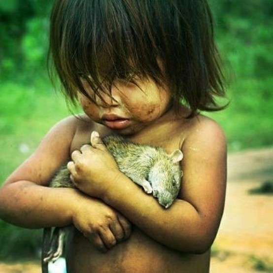 A Guaraní girl holds a dead rat. Guaraní are indigenous to the South American country of Paraguay.