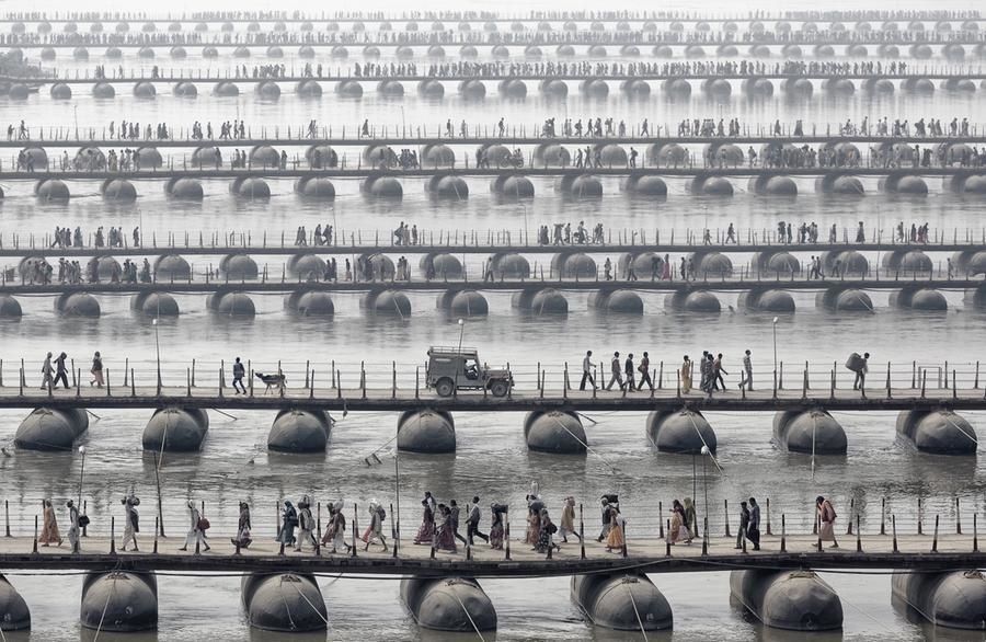People crossing bridges in India at the Maha Kumbh Mela.