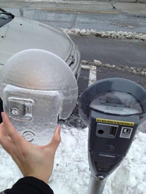 A perfectly frozen overcoat on top of a parking meter.