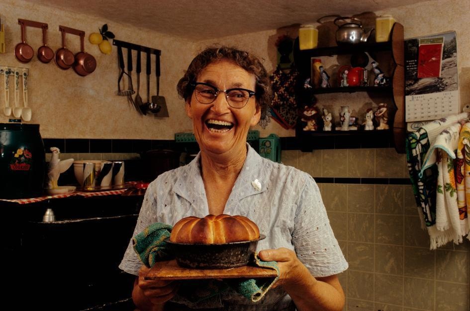 A gleeful woman presents some freshly-baked rolls at her home in Tangier Island, Virginia (1973).