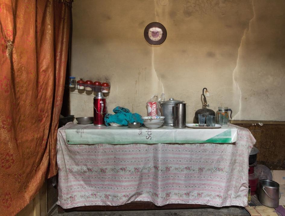 A table topped with pots and dishes is the kitchen area in this Aliabad home in Pakistan.