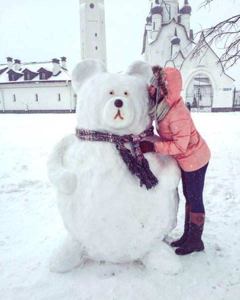 girl kissing a snowman