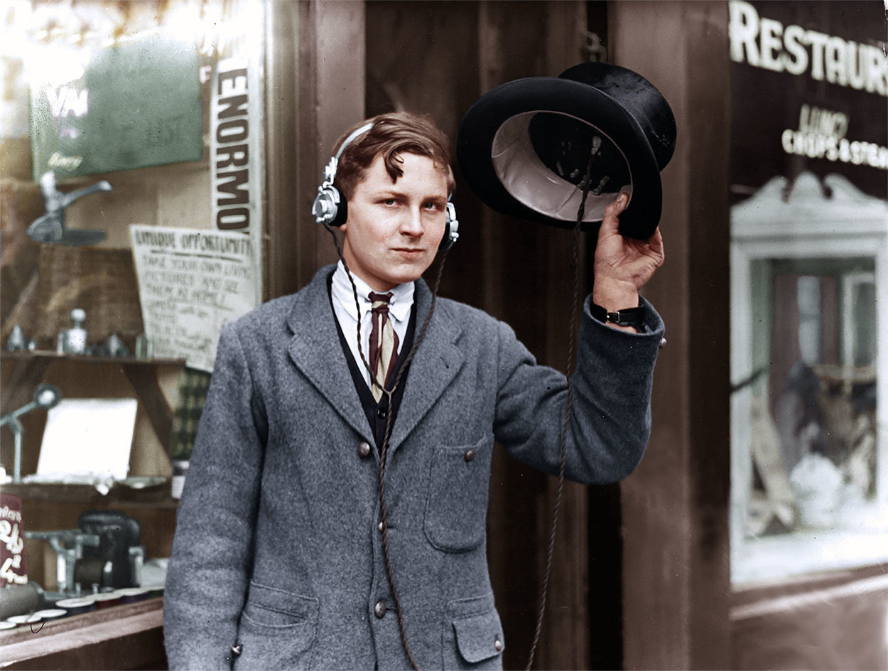 May 1922: H Day, an 18-year-old inventor, wears headphones attached to a wireless beneath his top hat.