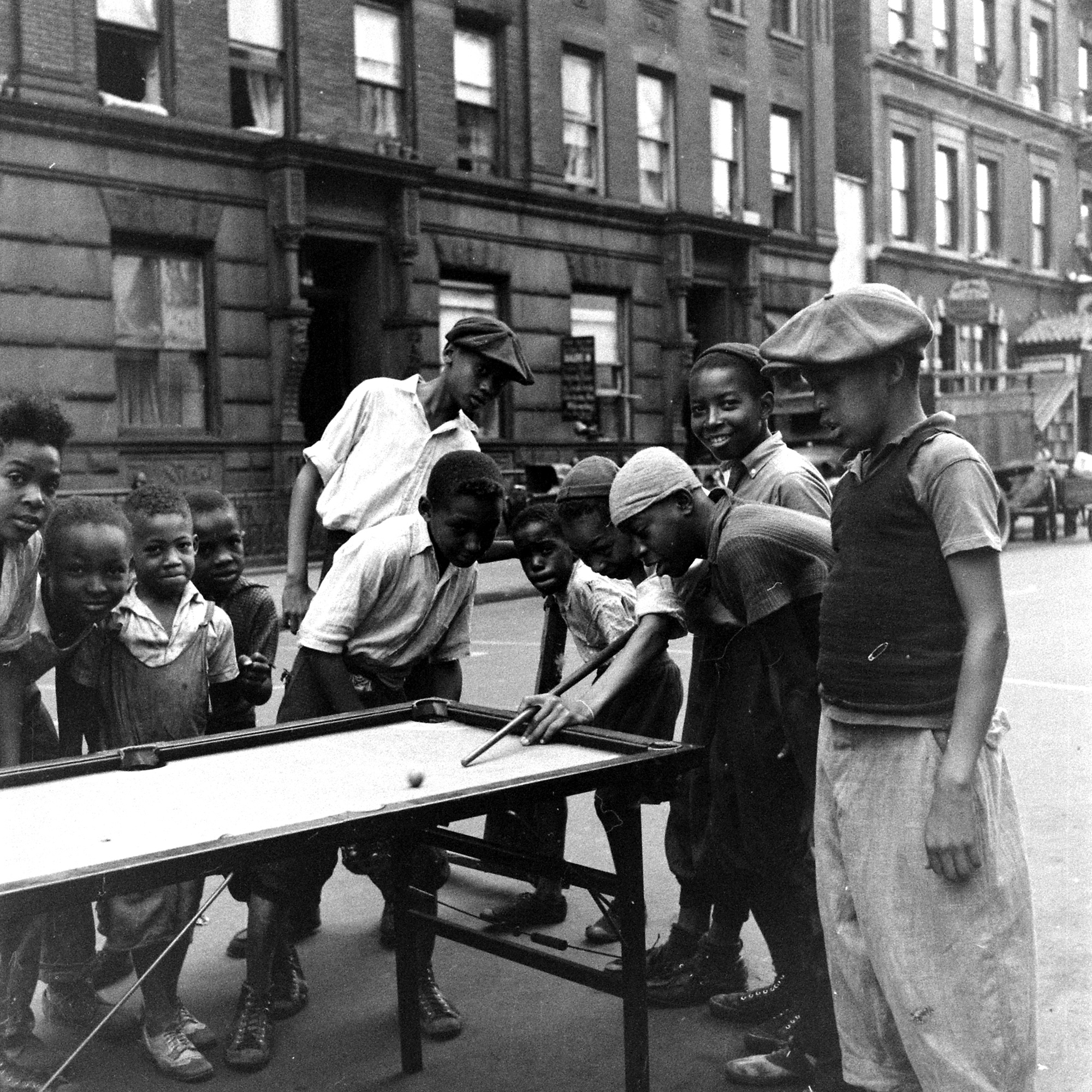 1938: A group of boys in Harlem enjoy a game of pool with a makeshift set-up.
