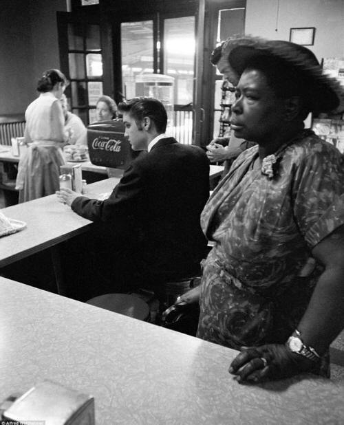 1956: Elvis Presley, who was known as a "white boy that could sing like a black man," is seen here at a segregated lunch spot in Tennessee. Although he avoided making political statements, he grew up around the black part of town and often credited the black community for their contributions to his music.
