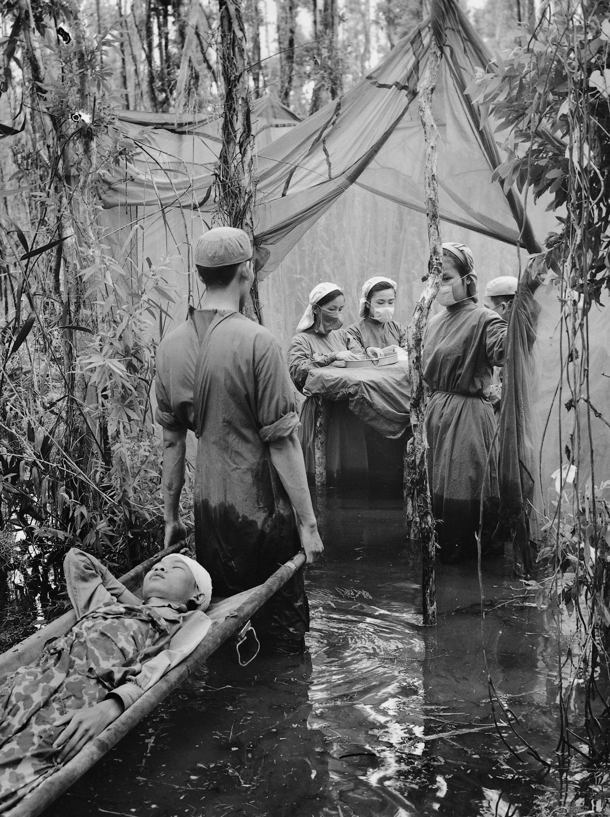 Sept. 15, 1970: Ethnic Cambodian guerrilla Danh Son Huol is treated for wounds from an American bombing at an improvised operating room in a swamp on the Ca Mau Peninsula.