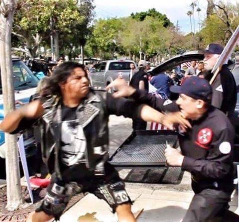 A punk about to knockout a klan member at Ku Klux Klan rally