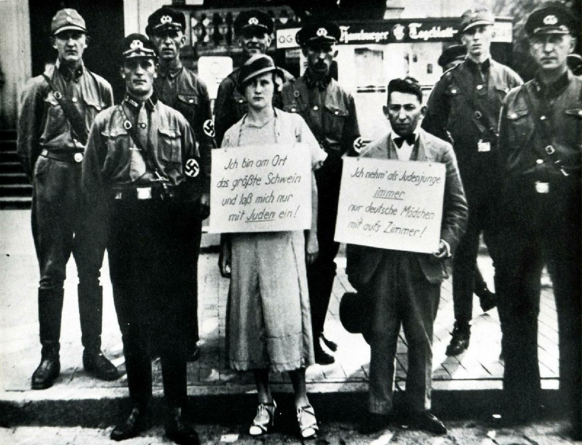 Two Germans accused of having violated the law against sexual relations between Jews and Gentiles – Hamburg The woman’s sign: “At this place I am the greatest swine for I laid with a Jew” The man’s: As a Jewish youth I always take only German girls to my room” , Germany, July 27, 1933. 

The Law for the Protection of German Blood and German Honour prohibited marriages and extramarital intercourse between Jews and Germans, and forbade the employment of German females under 45 in Jewish households. The Reich Citizenship Law declared that only those of German or related blood were eligible to be Reich citizens; the remainder were classed as state subjects, without citizenship rights