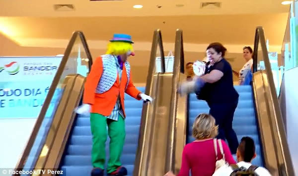 A woman who was seemingly minding her own business on an escalator got a sudden shock when a clown slapped her with a cream pie, prompting a hilarious reaction. She stormed down the escalator, attempting to hurl her handbag and her shoes at the entertainer.

The amusing video was filmed by a series of secret cameras in a shopping center in Brazil and was shown on a comedy TV show. 
It has already been viewed over 647,000 times on World Star Hip Hop, prompting dozens of comments about the woman's priceless reaction.