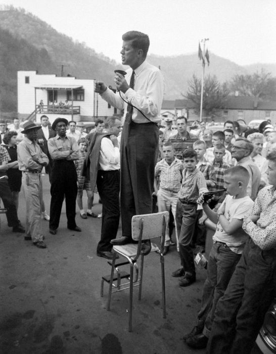 John F. Kennedy delivering a campaign speech in Logan County, West Virginia, standing on a kitchen stool.