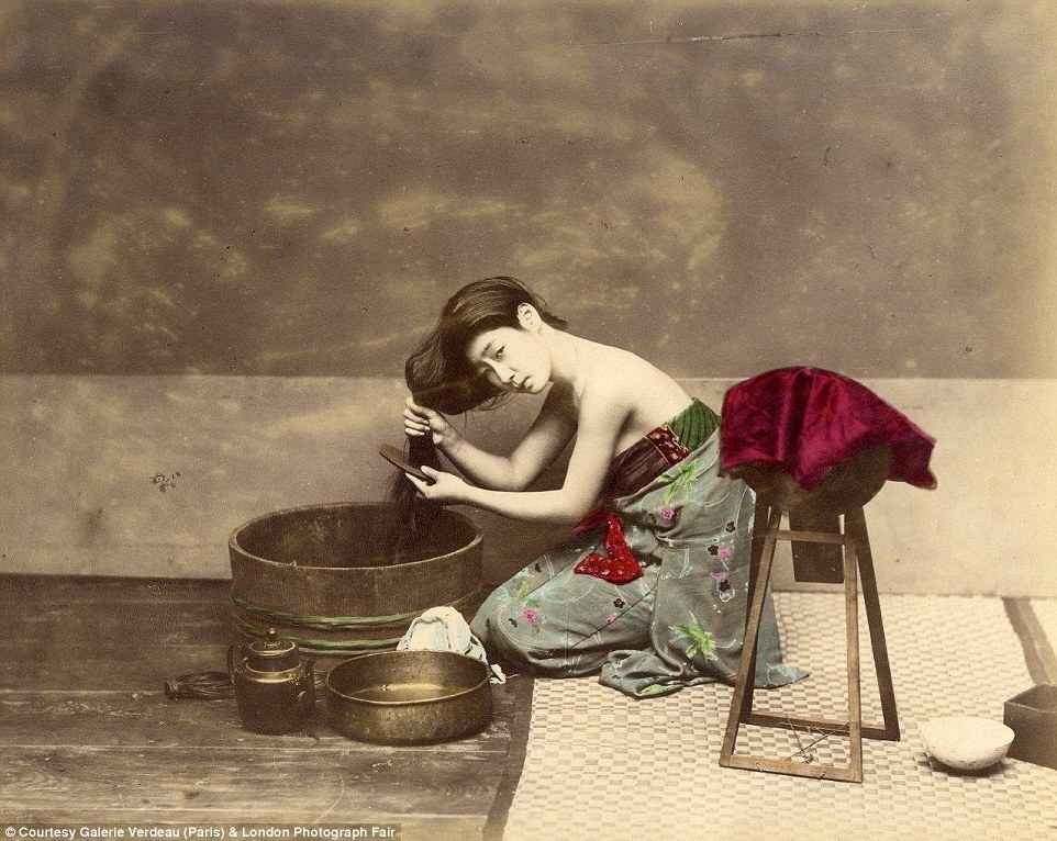 A Japanese woman combing her hair, sometime between 1863 and 1877.