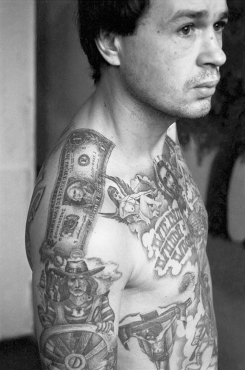 This convict’s tattoos were applied in the camps of the Urals where the tattoo artists produce work of exceptional quality. Because they were so held in such high regard, criminals often attempted to be transferred there in order to be tattooed. The dollar bill on the shoulder signifies the bearer’s commitment to a life of crime.