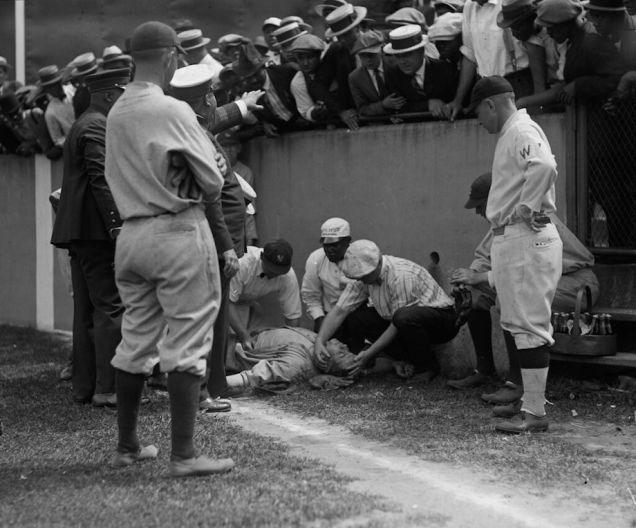 Babe Ruth lying unconscious after running into a wall chasing a fly ball. He would regain consciousness 5 minutes later and get 2 more hits in the game. July 5, 1924