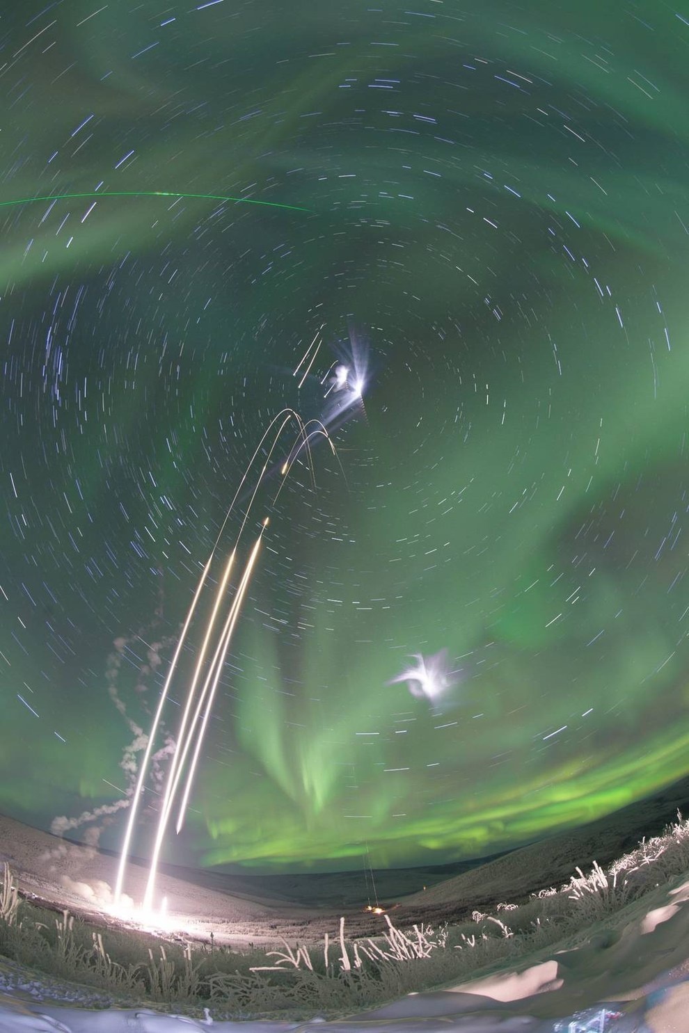 A composite image of four rockets as they are being launched from NASA's Poker Flat Research Range in Alaska and into the aurora borealis.