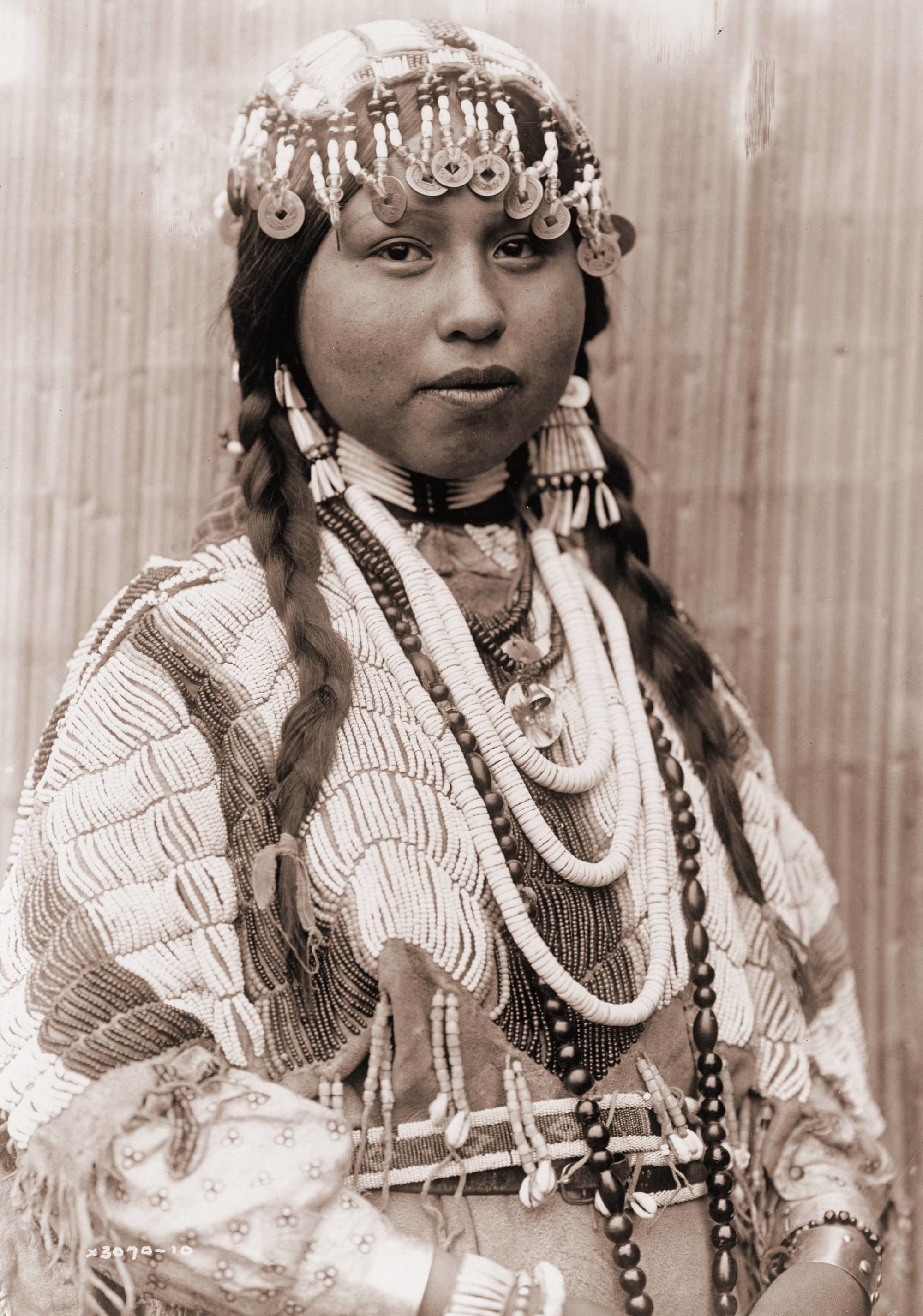 The title of this photo is "Wishram woman in festive bridal raiment", by Edward S. Curtis.