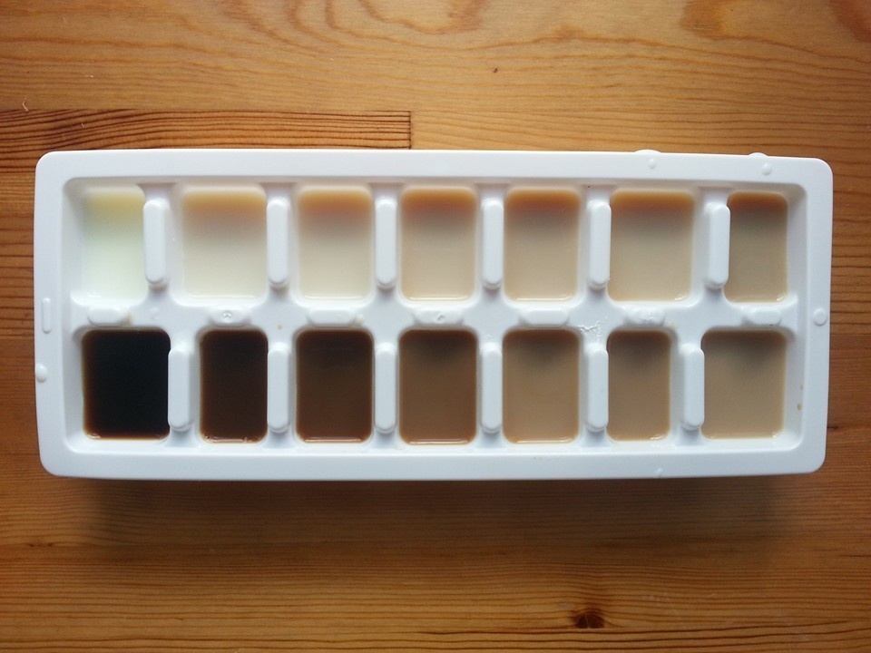 A gradient of iced coffee in an ice cube tray.