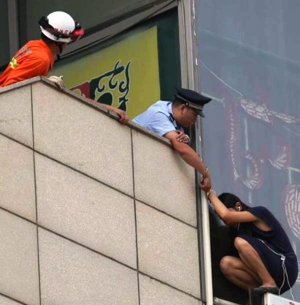 This brave police officer handcuffed himself to a woman who was trying to commit suicide in Beijing, China. The woman knew that if she died, she would take the policeman with her and that seemed to bring her back. The officer later hauled her back onto the building where he stood.