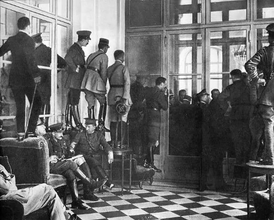 Military officers and politicians climbing over furniture to watch the signing of the Treaty of Versailles in the aftermath of World War 1 – June 28th, 1919