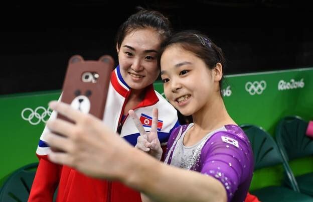 Gymnasts from North & South Korea take a selfie together at the Olympics
