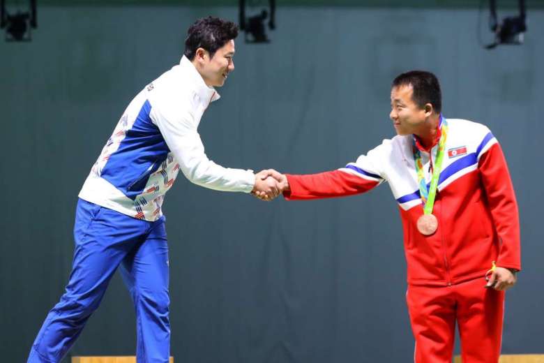 Olympic shooters from both Koreas shakes hands during the medal ceremony