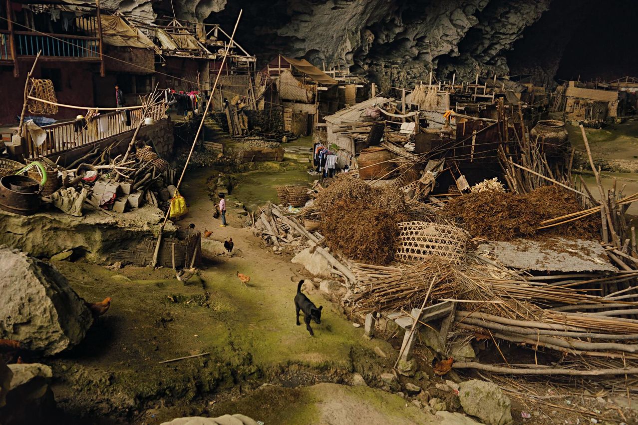 In a giant cave in China, there live 21 families. This cave now contains a basketball court and even a school