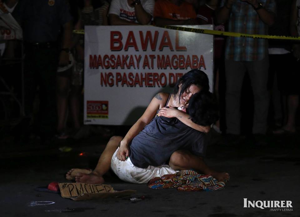 A weeping Jennelyn Olaires hugs partner Michael Siaron, 30, a pedicab driver and alleged drug pusher, who was shot and killed by motorcycle-riding gunmen near Pasay Rotonda, Philippines