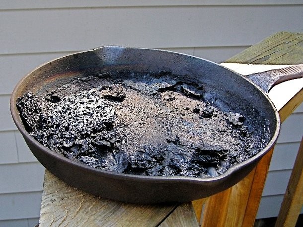 To clean a burnt pan effortlessly, fill it with a shallow layer of water, and add 1 cup of white vinegar. Let it warm up on the stove for a few minutes. Then add 2 tablespoons of baking soda once you take it off the burner. Now you can scrub the burnt residues with ease.