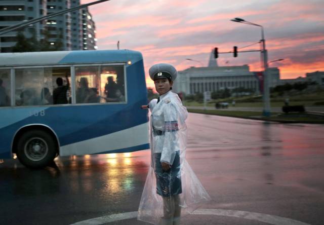 A traffic officer directs vehicles at sunset in Pyongyang, the nation's capital, on August 25th, 2016.