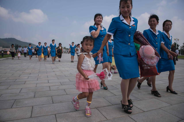 Families wait in long lines to pay their respects to fallen leader Kim Jung Un on the anniversary of his death.