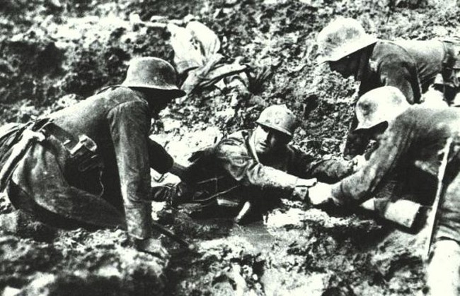 Three German soldiers help a Frenchman stuck in the muddy fields of Verdun. [World War I, c. 1916]