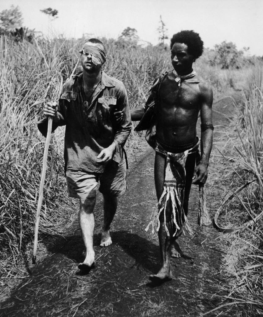 A native of Papua New Guinea, who were nicknamed ‘Fuzzy Wuzzy Angels’ because of their hairstyle and kind nature, escorts a wounded Australian soldier out of the bush. [World War II, 1942]