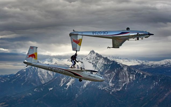 Red Bull has a long history of sponsoring some pretty crazy and extreme endeavors, from their annual cliff-diving competitions to Felix Baumgartner's space jump, to Robbie Madison's motorcycle jump onto the Arc de Triomphe in Paris in 2008. 

But — even for Red Bull — this stunt is pretty insane. In the video below, parachute and skydive master Paul Steiner casually switches gliders in mid-air, hanging off the wing of one to drop onto the top of the other.
If that wasn't enough, he then proceeds to grab the tail of the first glider (which flips upside down) while standing on the second.