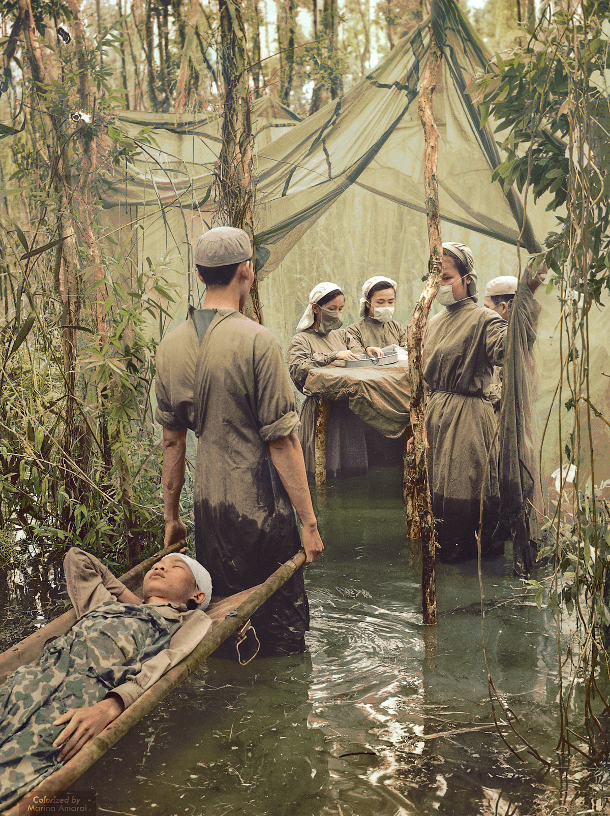 A victim of American bombing, ethnic Cambodian guerrilla Danh Son Huol is carried to an improvised operating room in a mangrove swamp on the Ca Mau Peninsula 1970