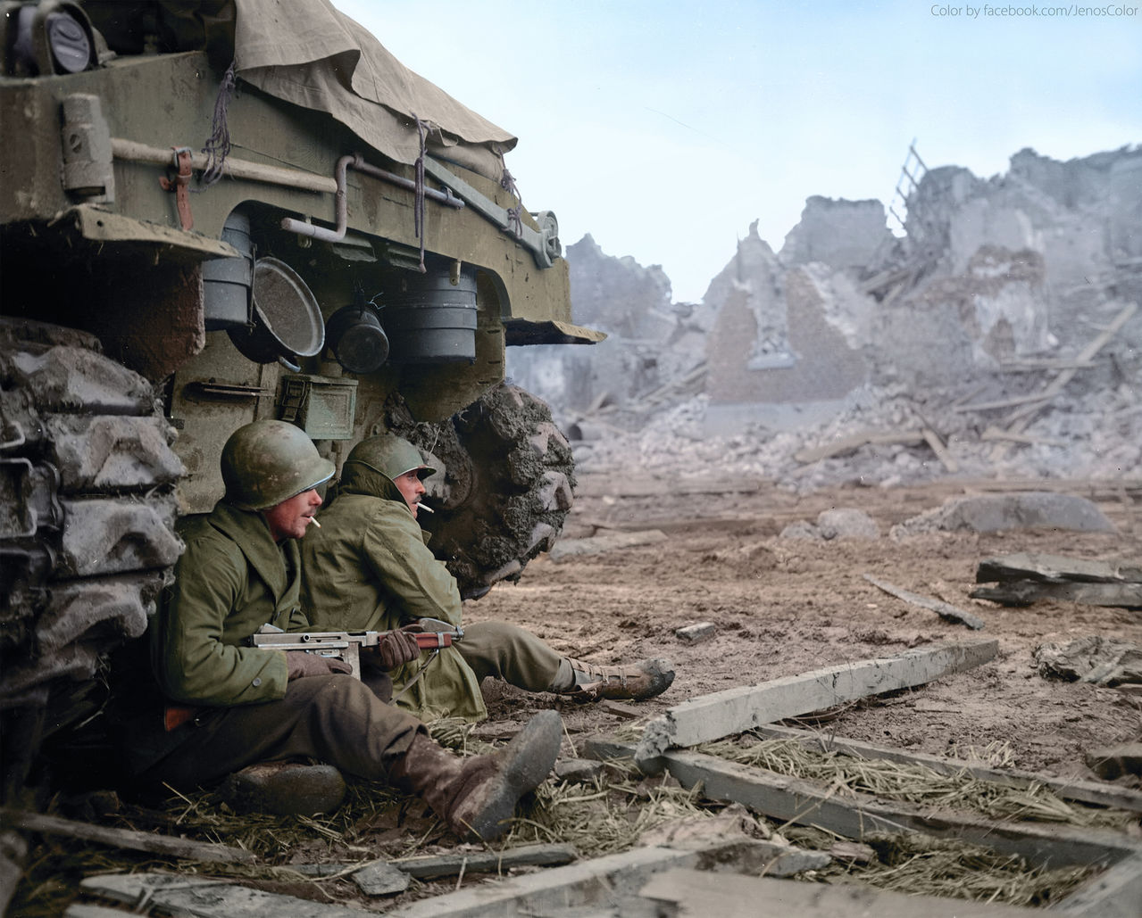 Two U.S. soldiers of C Company, 36th Armored Infantry Regiment, 3rd Infantry Division seek shelter behind a M-4 Sherman tank at Geich, near Düren, Germany, on 11 December 1944.