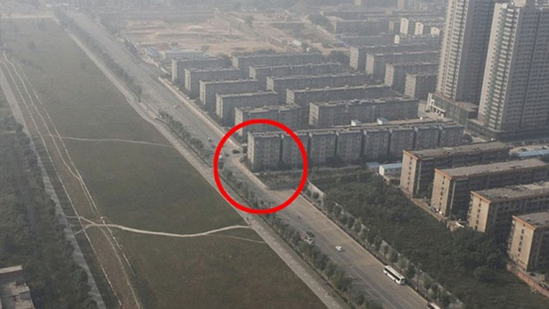 Chinese Contraction Project Accidentally Puts Apartment Building In Middle Of Highway. OK, compared to war crimes and forced gulag labor this one is NOT that bad. However with China pushing forward on loads of urban development projects and planning, there are bound to be some funny mistakes. Thankfully nobody died in this incident, but a few apartment dwellers have sort of a terrifying view. The government moved out residents of a section of Xi’an, Shaanzi province to make room for a public park.  In exchange they would be promised placement in a brand new block of apartments. The only problem was that when they built the nice new apartment buildings for the people who lived where the park is going, they accidentally placed one of the buildings right in the path of a EIGHT lane highway.