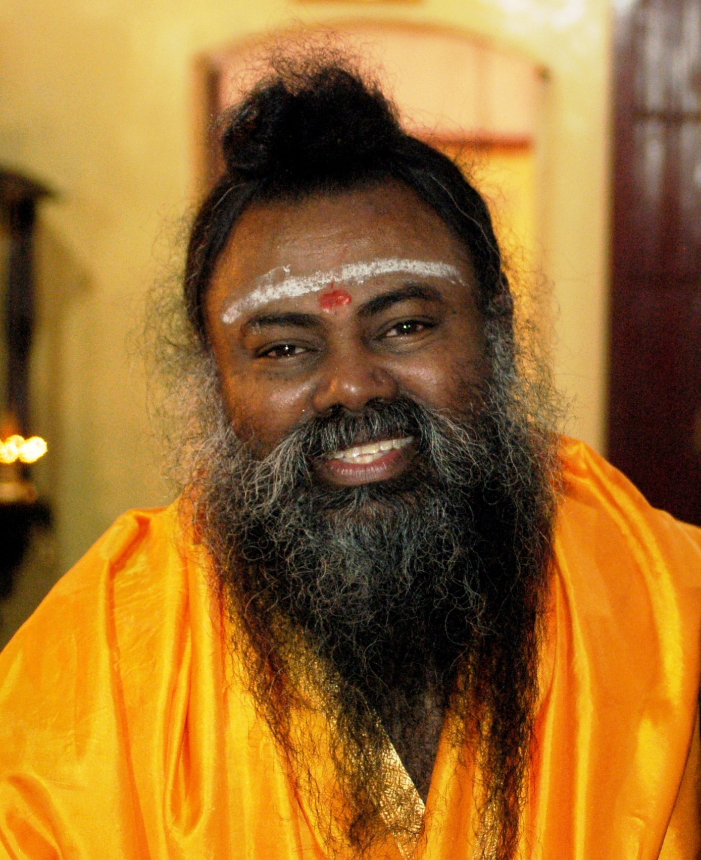 Cult Leader Swami Premananda wearing yellow outfit and smiling