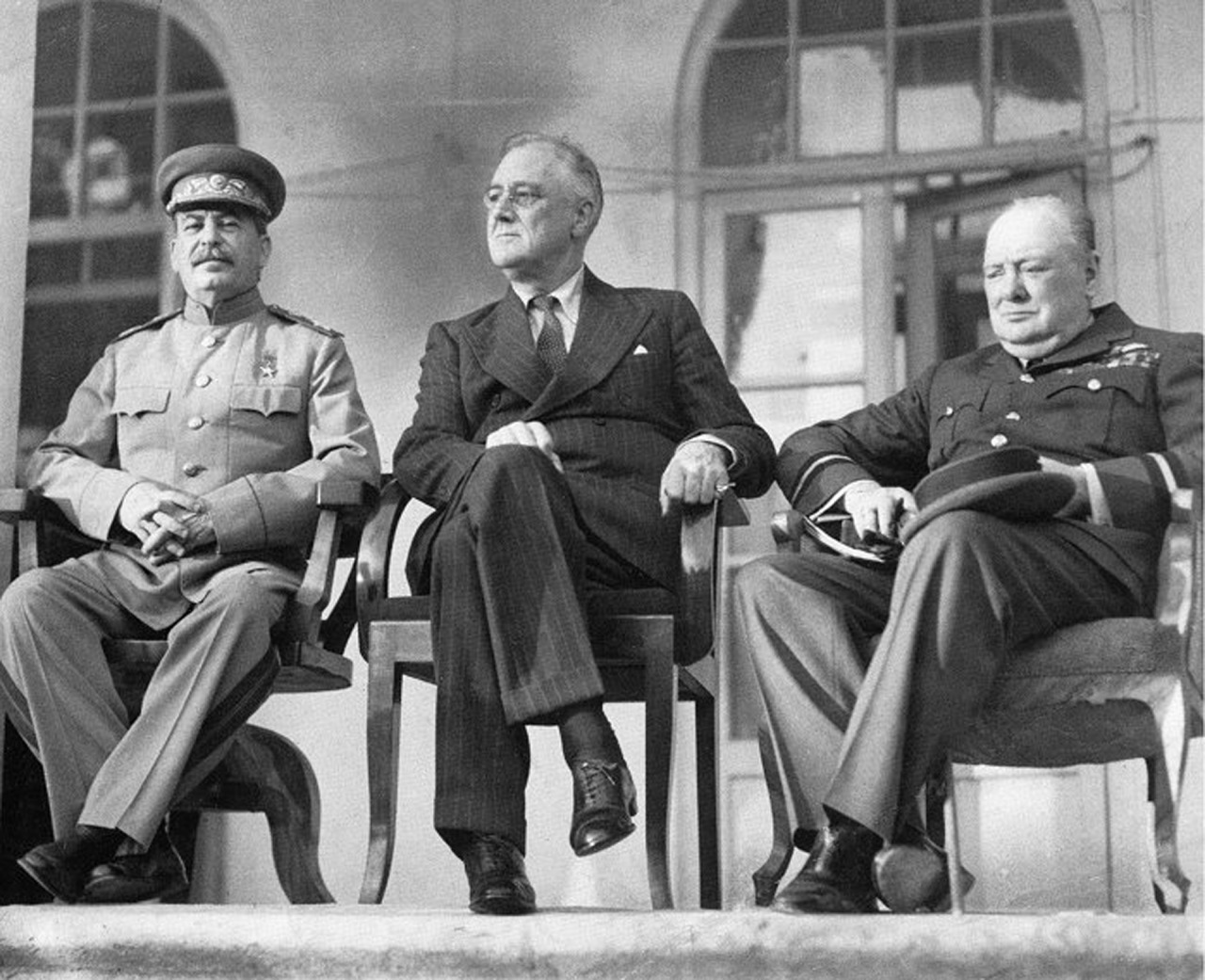 The “Big Three” – Stalin, Roosevelt and Churchill – meet at the Tehran Conference, 1943.

Roosevelt was mostly wheelchair bound…he and his staff went to great lengths to keep this quiet. So out of courtesy/respect to him, the other world leaders most likely elected to sit down next to him so he would not look inferior sitting next to the others while standing.