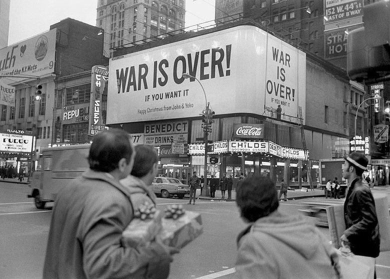 John Lennon and Yoko Ono’s billboard in Times Square during the increasing opposition of continuing the Vietnam War, 1969.

“Happy Xmas (War Is Over)” was the culmination of more than two years of peace activism undertaken by John Lennon and Yoko Ono that began with the bed-ins they convened in March and May 1969, the first of which took place during their honeymoon. The song’s direct antecedent was an international multimedia campaign launched by the couple in December 1969 – at the height of the counterculture movement and its protests against America’s involvement in the Vietnam War – that primarily consisted of renting billboard space in 12 major cities around the world for the display of black-and-white posters that declared “WAR IS OVER! If You Want It – Happy Christmas from John & Yoko”.