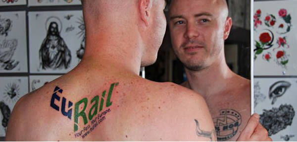 Grant Burton wanted to get his parents something special for their 40th wedding anniversary, but he was unemployed and didn't have much cash to spare. Knowing his parents always wanted to go to Europe, Grant contacted EuRail and asked them if they would give him two passes if he did something crazy to promote their brand.

 He offered to have their logo and website permanently tattooed on his back. Amazingly, they said yes. Now Grant has to get used to telling this story every time he takes his shirt off.
