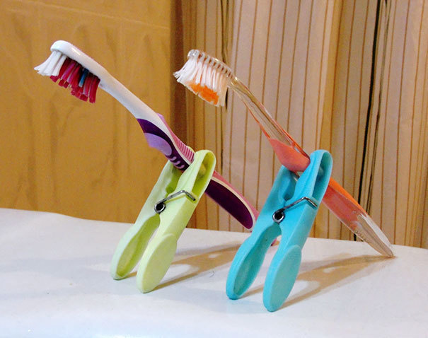 When you're traveling, you shouldn't let your toothbrushes touch the dirty counter! Use clothes pins as a stand for your toothbrushes.